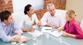 Four businesspeople in boardroom talking